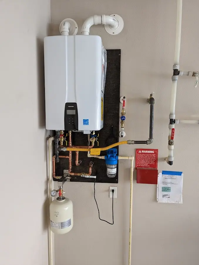 Professional plumber installing copper piping in a Ballville home